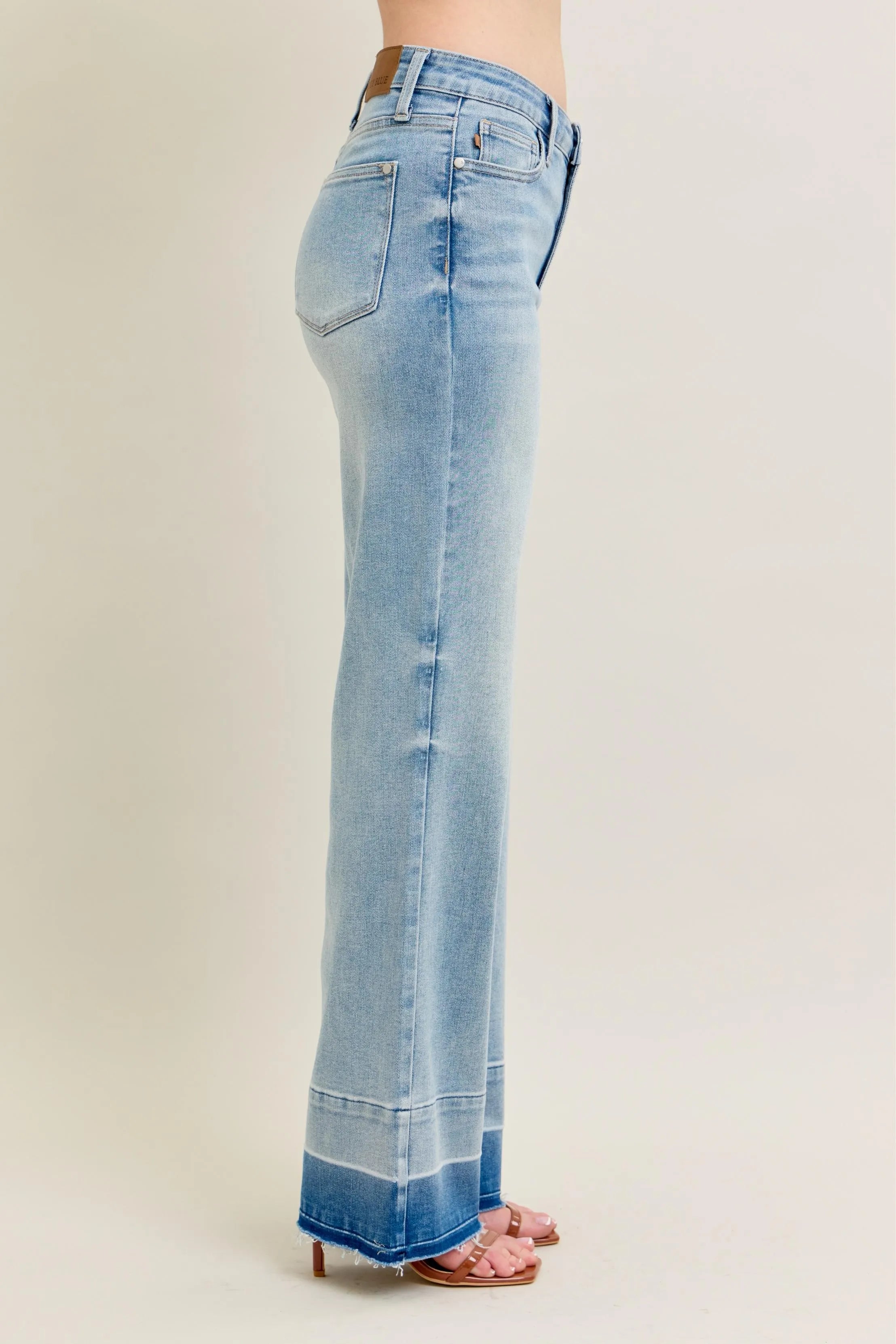 Light blue flared jeans on a beige background