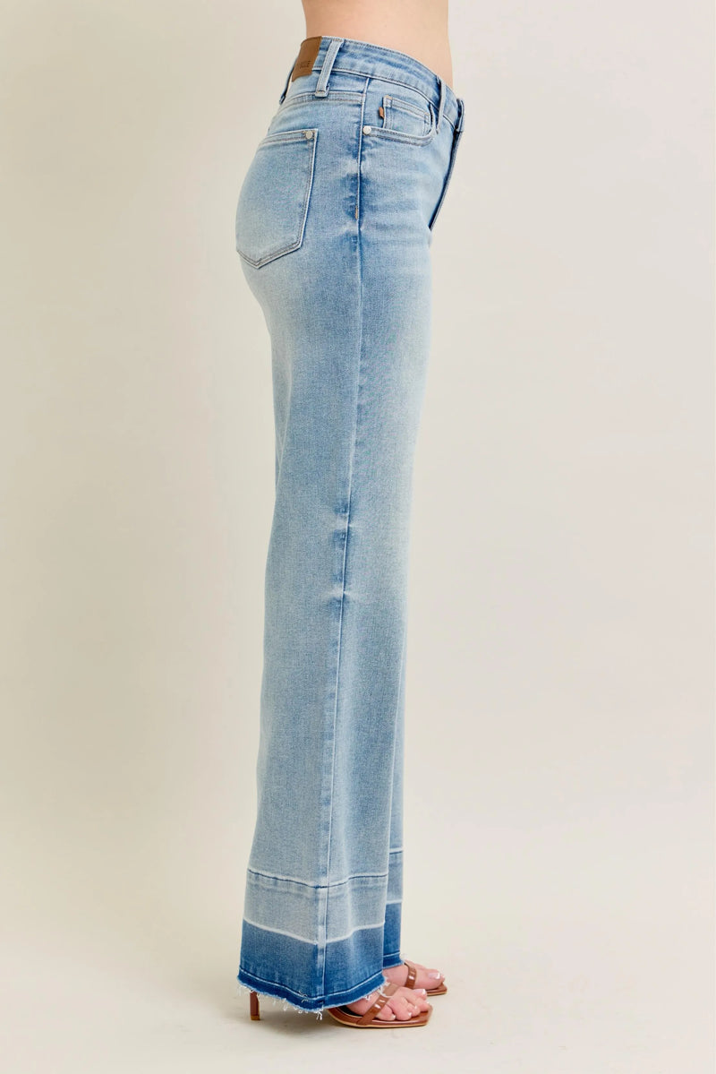 Light blue flared jeans on a beige background