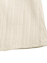 Close-up of a textured beige fabric corner on a white background