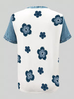 White shirt with blue floral patterns and denim sleeves on a light gray background