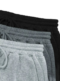 Stack of black and gray sweatpants on a white background