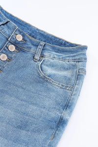Close-up of blue denim jeans with buttons on a white background