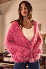 Woman wearing a pink cardigan in an indoor setting