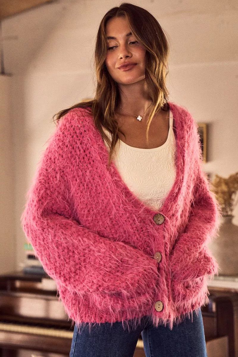 Woman wearing a pink cardigan in an indoor setting