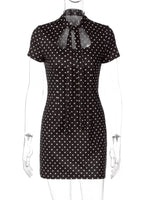 Black dress with white polka dots on a mannequin against a white background