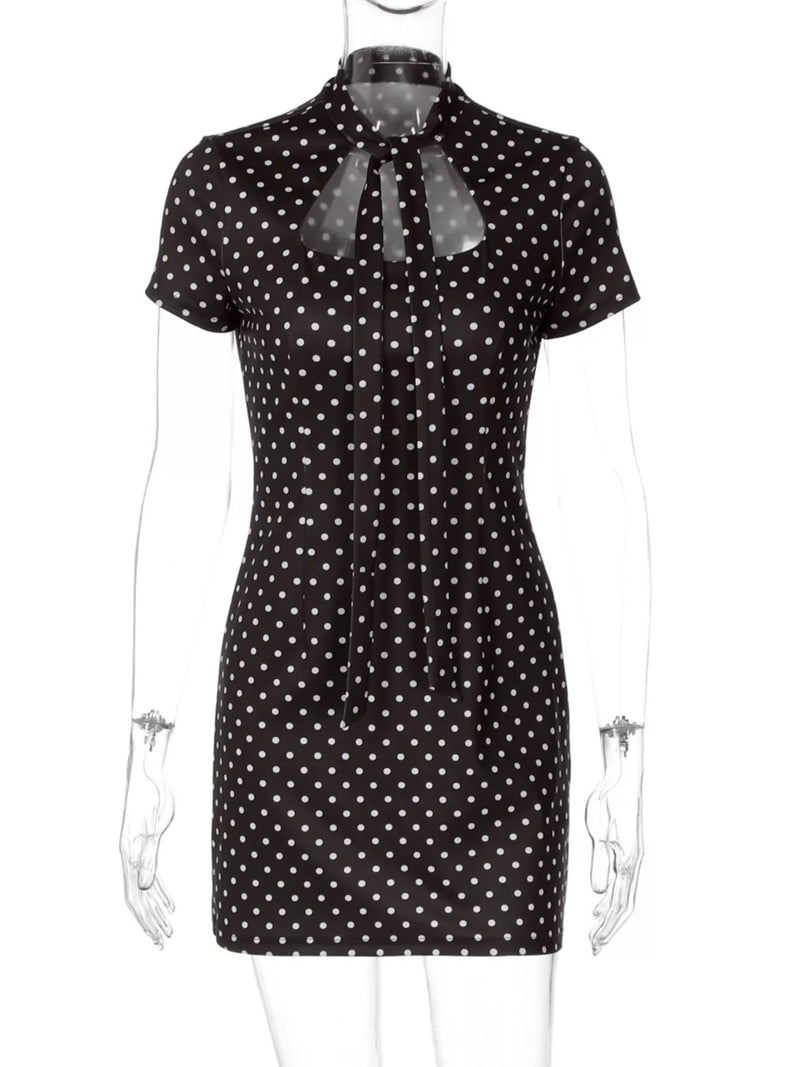 Black dress with white polka dots on a mannequin against a white background