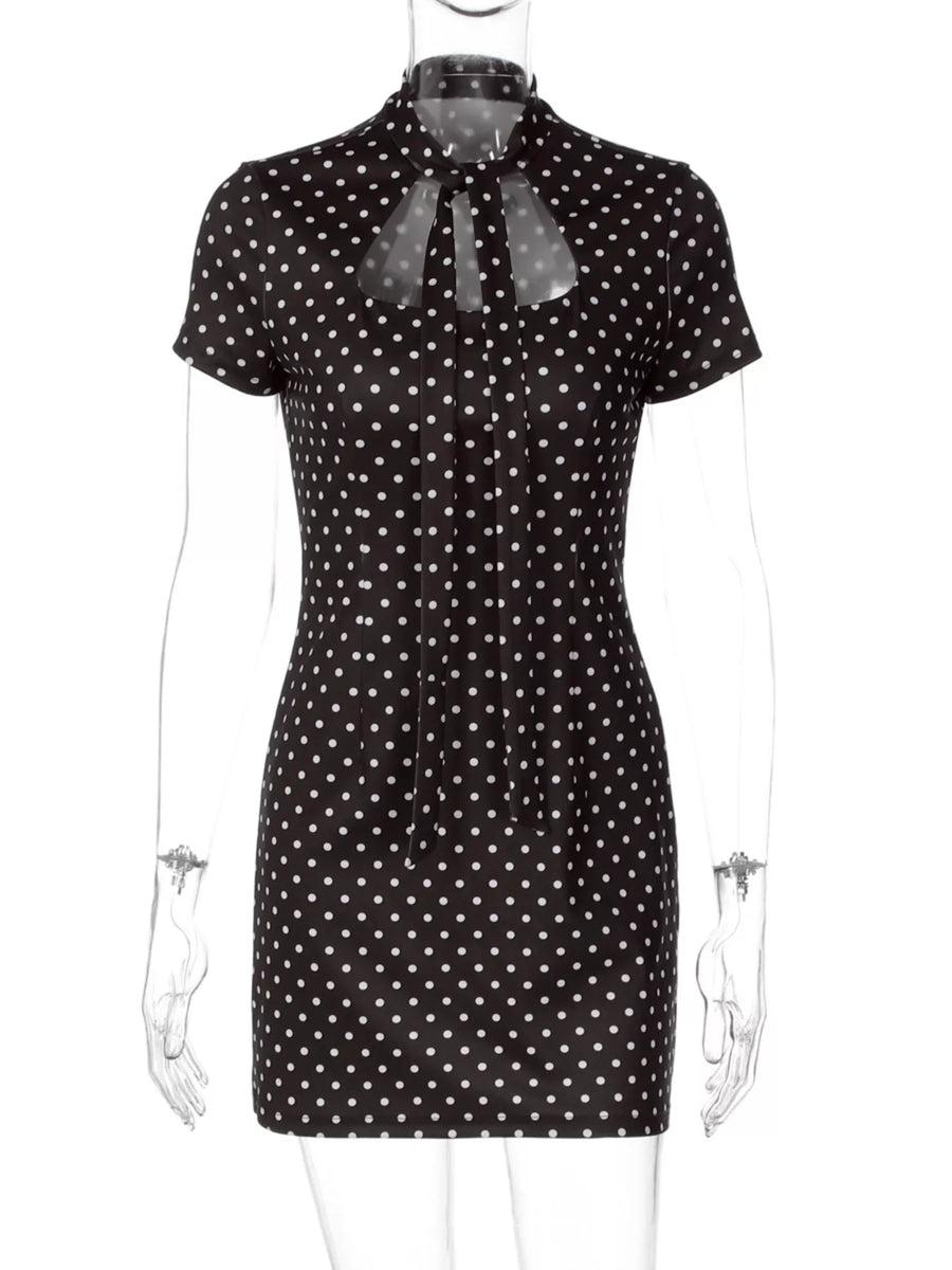 Black dress with white polka dots on a mannequin against a white background