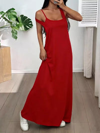Woman wearing a red dress standing indoors with a plant and white door in the background