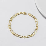 Gold chain bracelet on a light gray background
