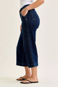 Person wearing blue jeans on a plain background