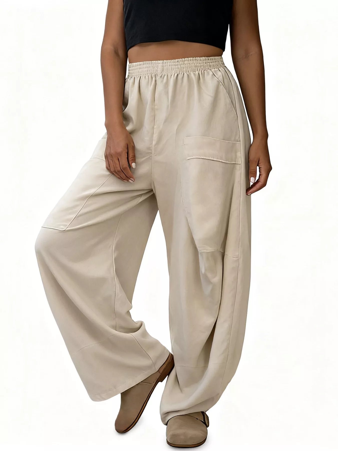 Beige wide-leg pants worn by a person on a white background