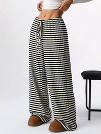 Black and white striped pants worn by a person on a white background