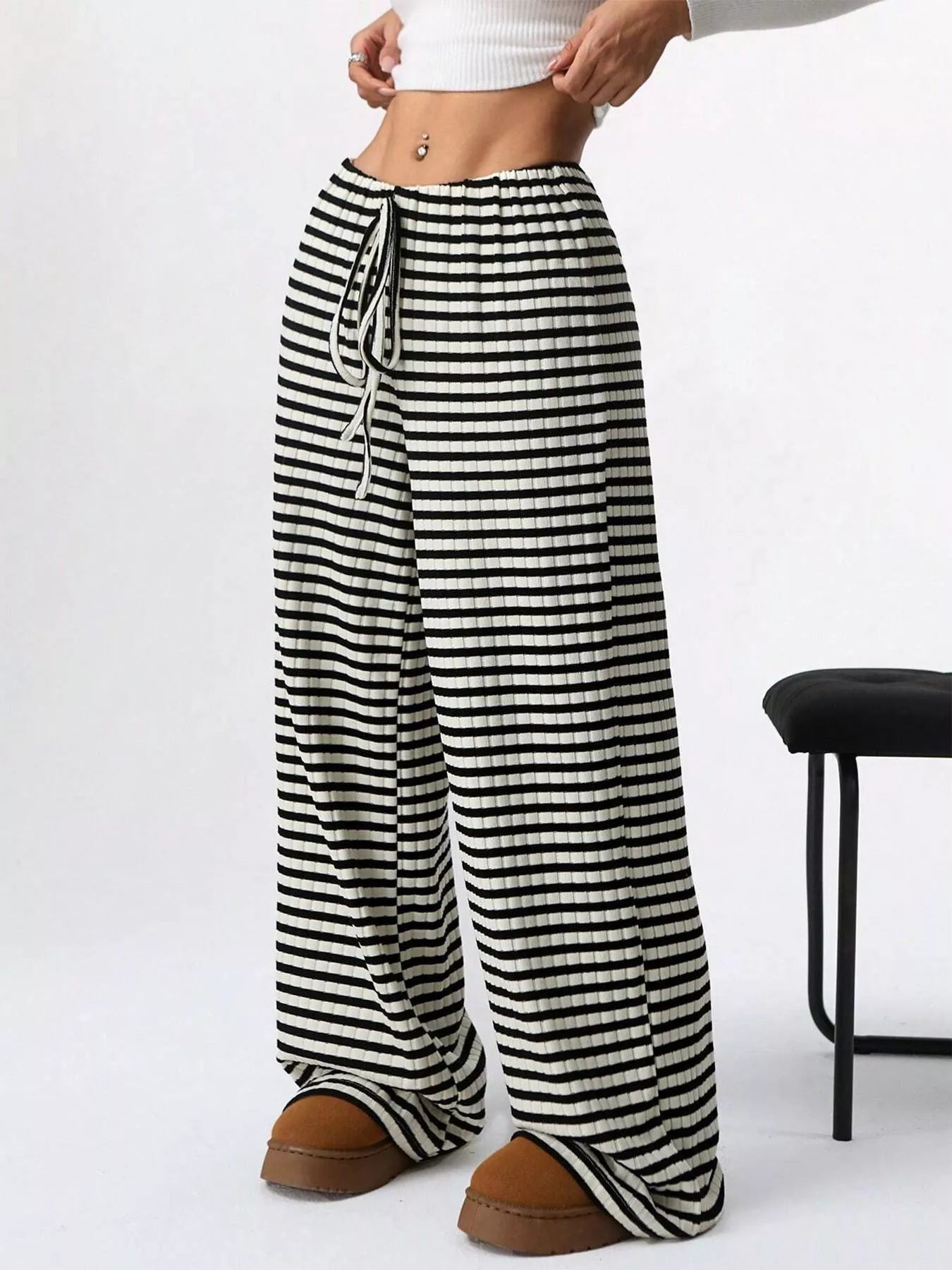 Black and white striped pants worn by a person on a white background