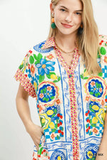 Woman wearing a colorful patterned shirt with a white background