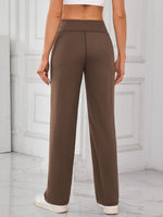 Brown pants worn by a person on a light gray floor with white paneled walls.
