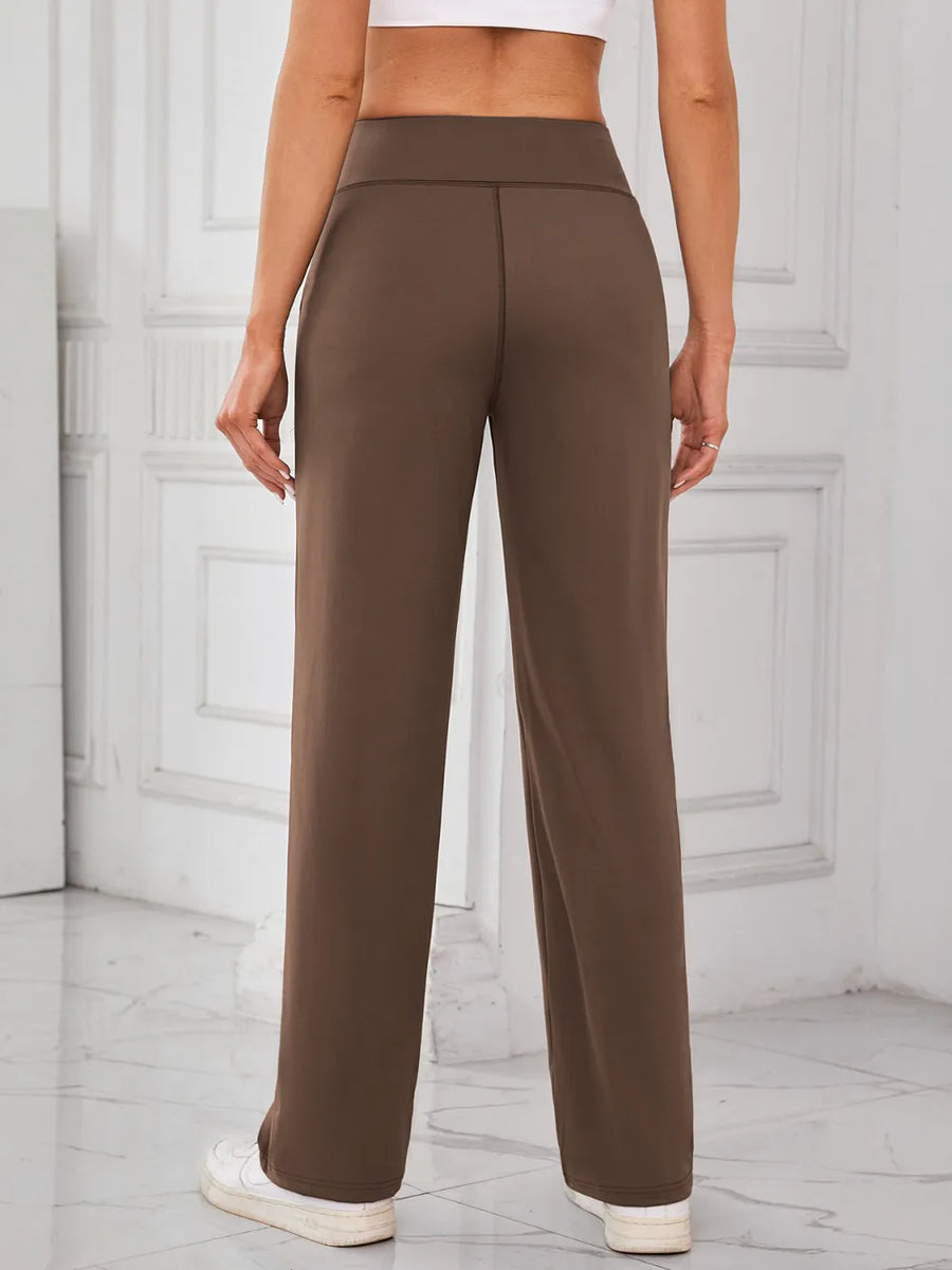 Brown pants worn by a person on a light gray floor with white paneled walls.