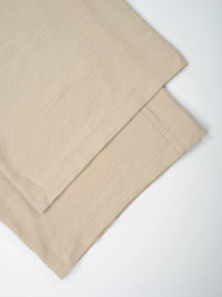 Beige bed sheets on a white background