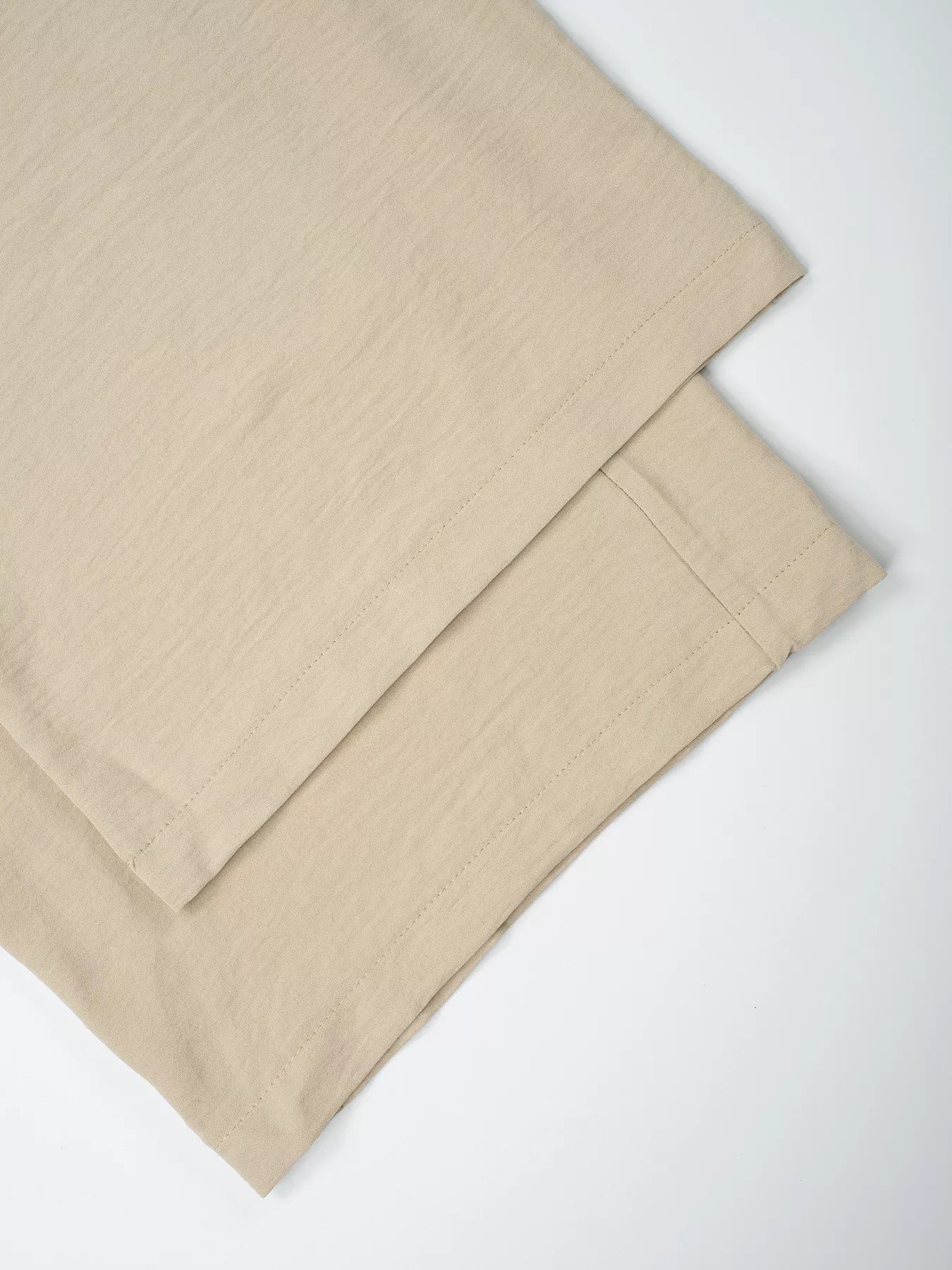 Beige bed sheets on a white background