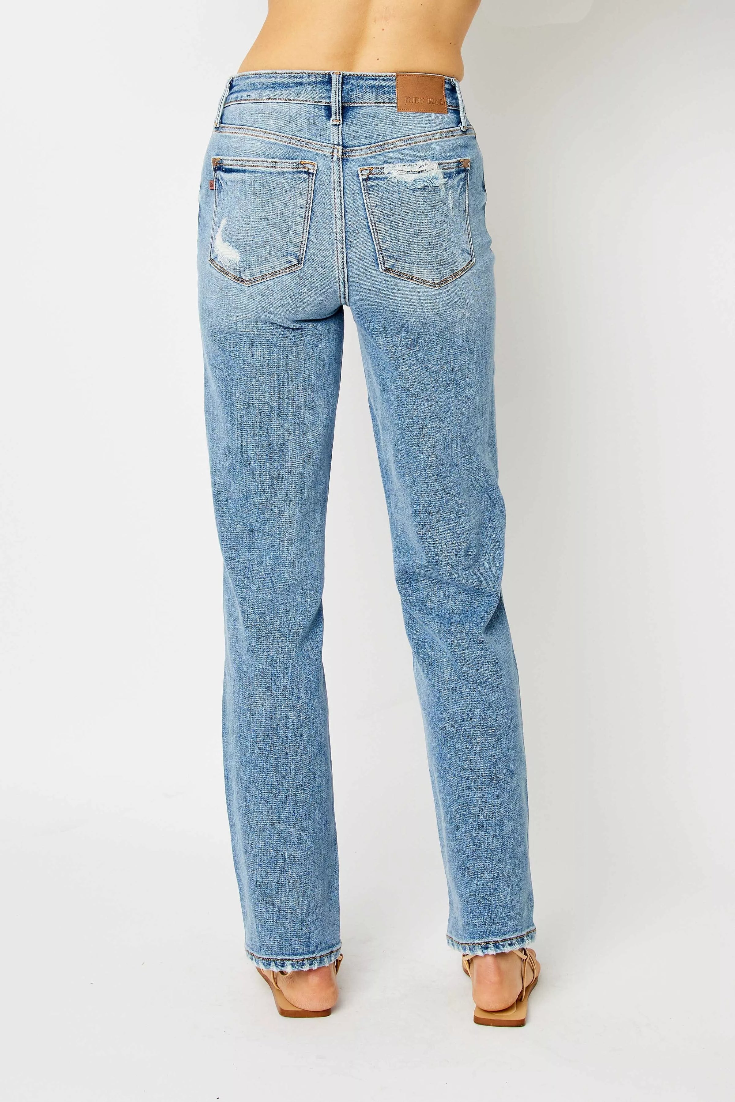 Light blue jeans worn by a person on a white background
