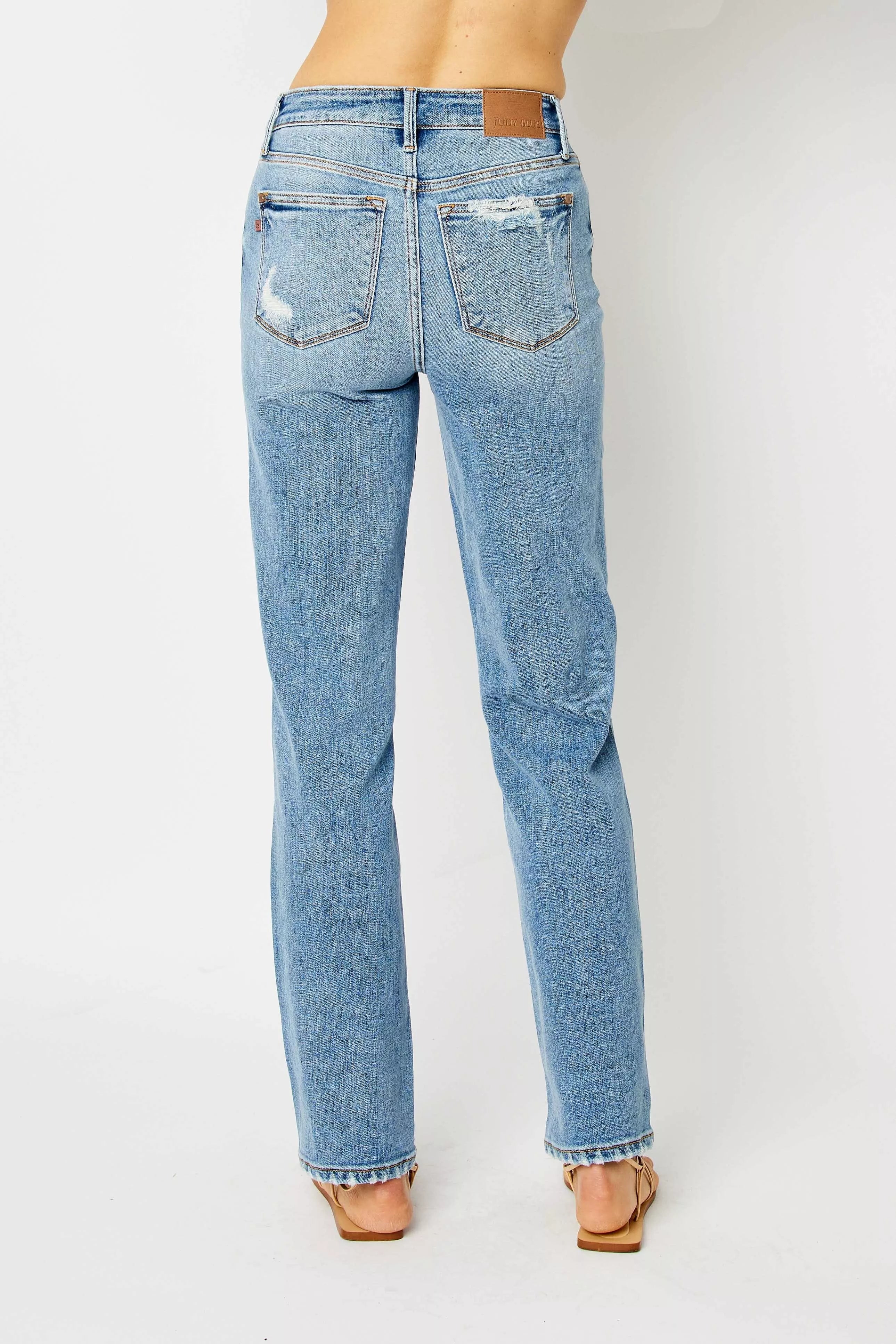 Light blue jeans worn by a person on a white background