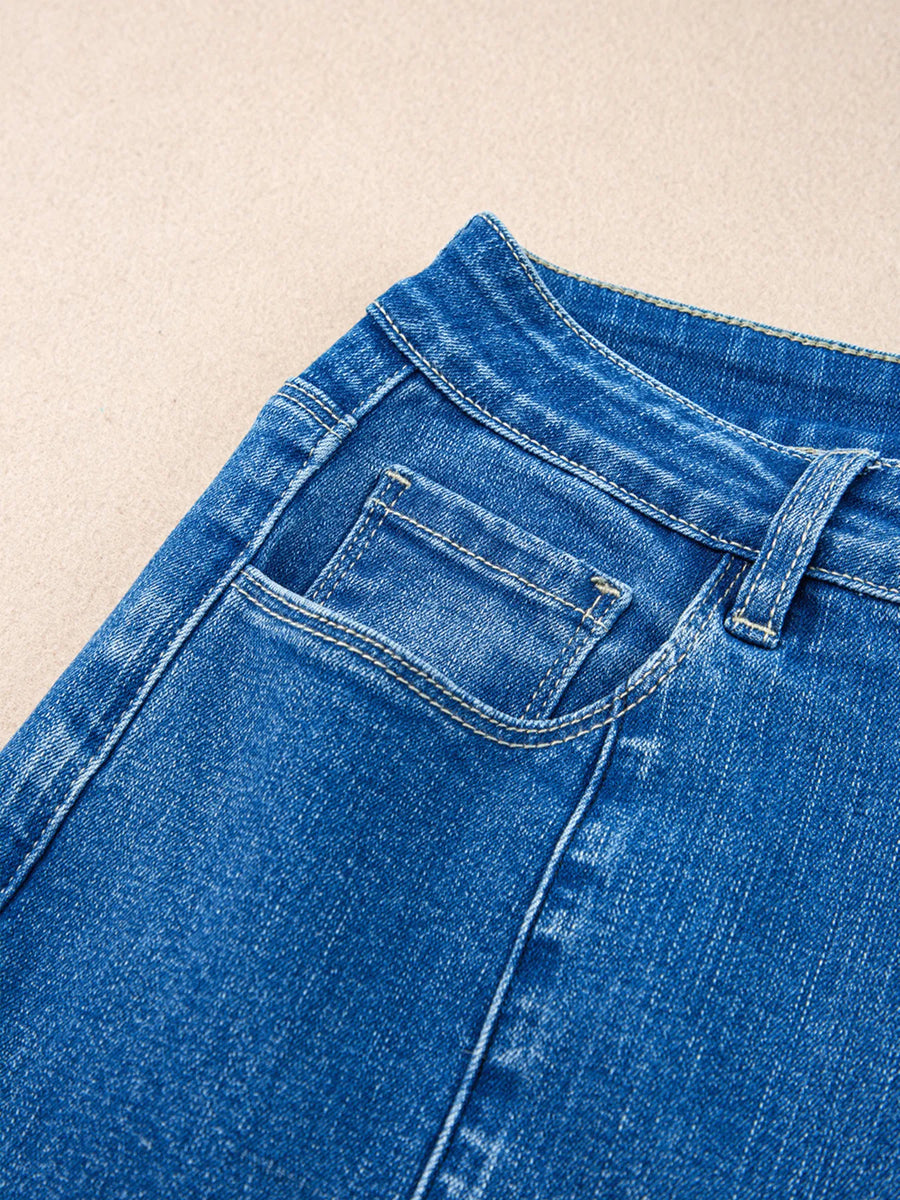 Close-up of blue denim jeans on a beige background