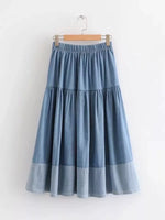 Blue denim skirt on a hanger against a white background