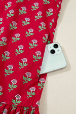 Red fabric with floral pattern holding a smartphone on a beige surface