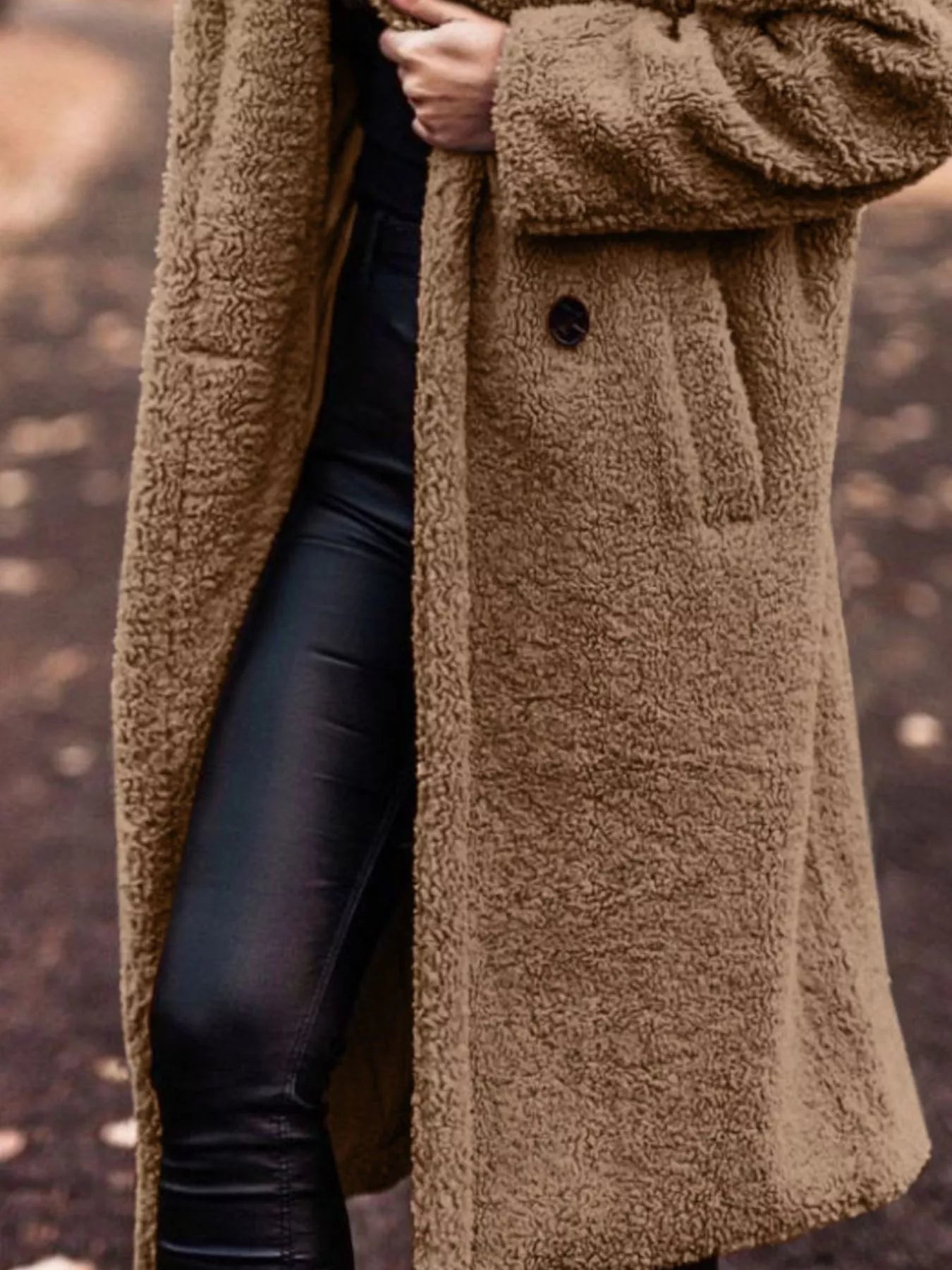 Brown teddy coat worn by a person with a blurred background