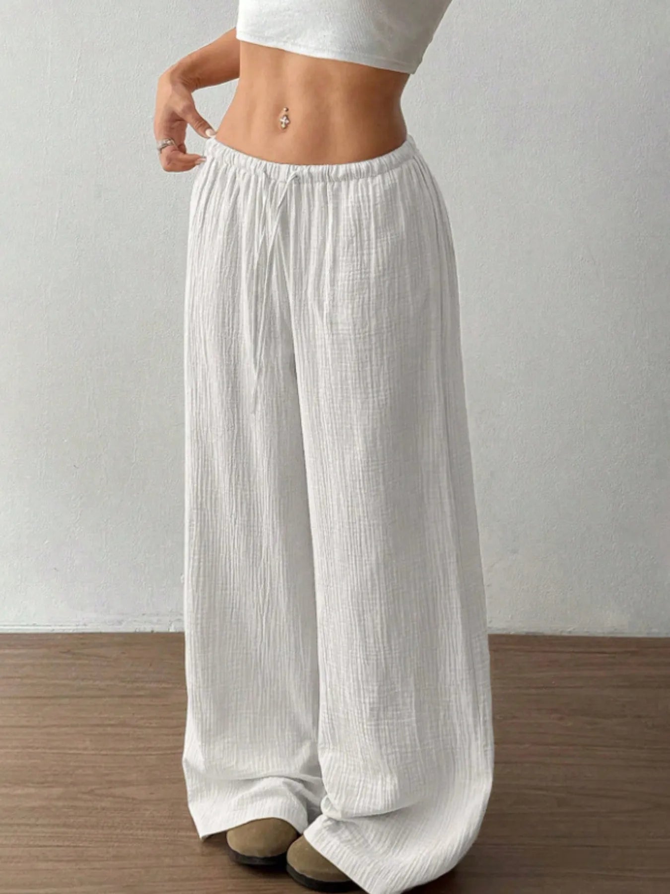 White wide-leg pants worn by a person on a plain background