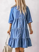 Woman wearing a blue denim dress against a plain background