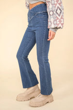 Person wearing blue jeans and beige shoes on a beige background