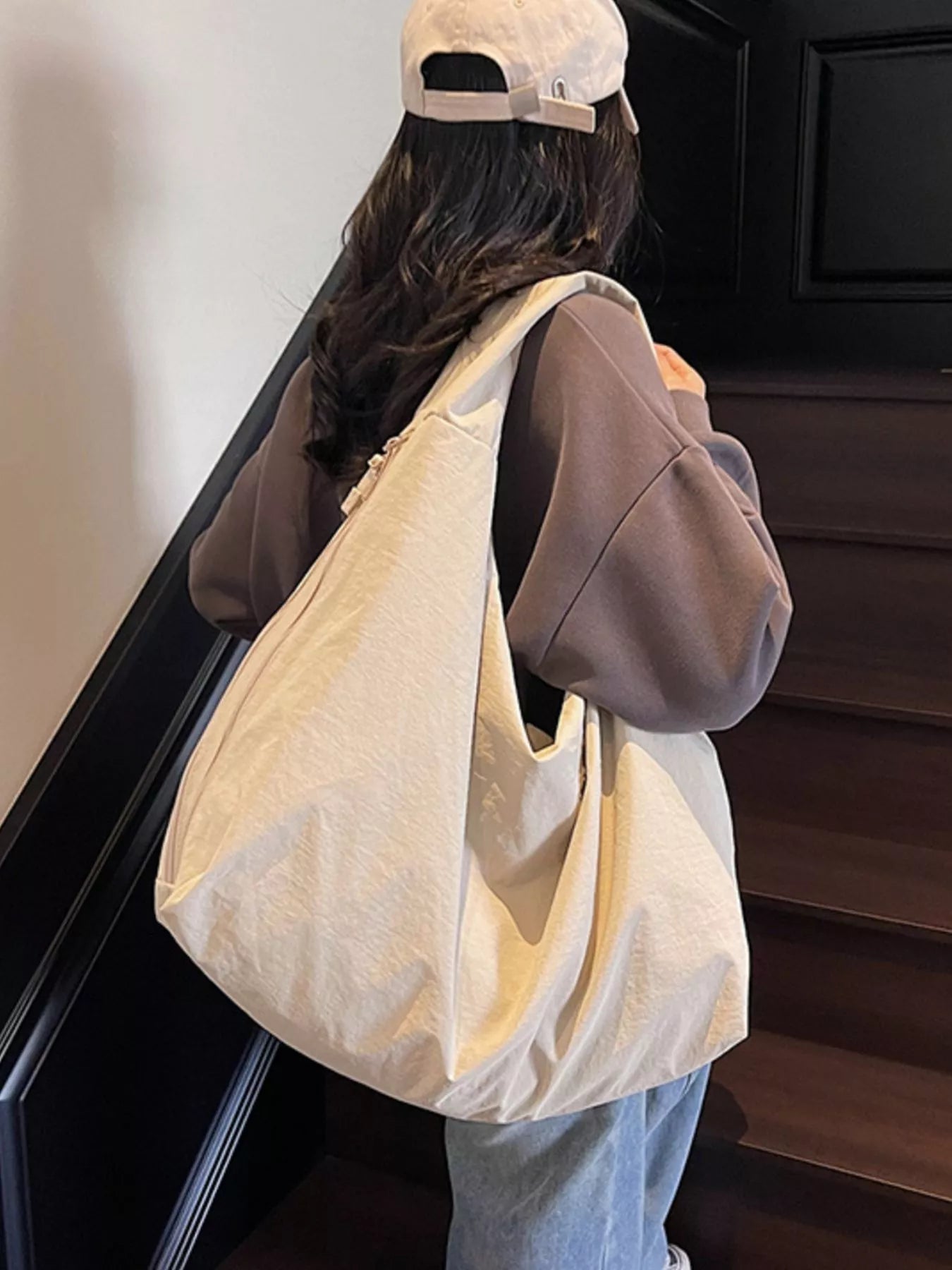 Person holding a beige tote bag on a staircase
