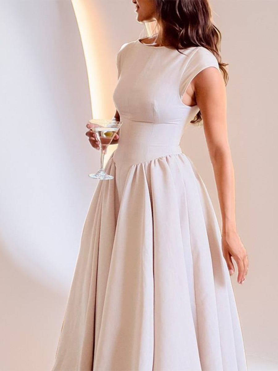 Woman wearing a white dress holding a martini glass against a plain background