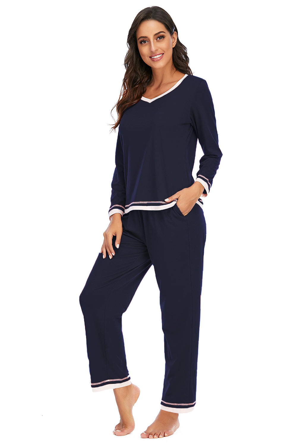 Woman wearing navy blue pajamas with white trim on a white background