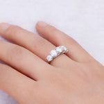 Silver ring with three diamonds on a hand against a light background