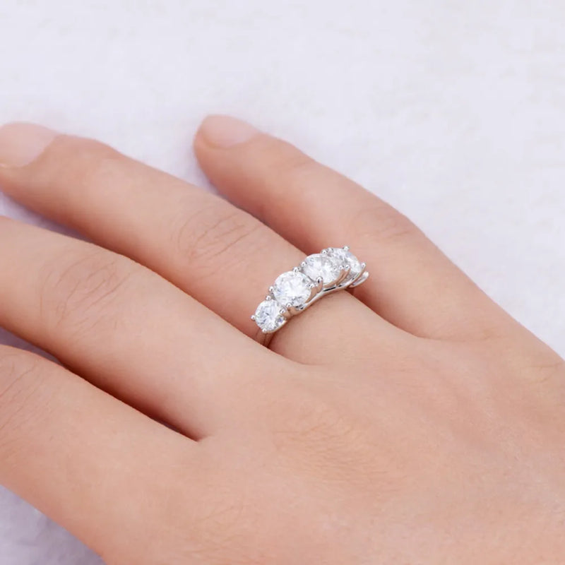 Silver ring with three diamonds on a hand against a light background