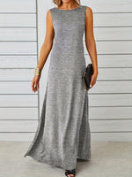 Woman wearing a gray sleeveless maxi dress against a wooden background