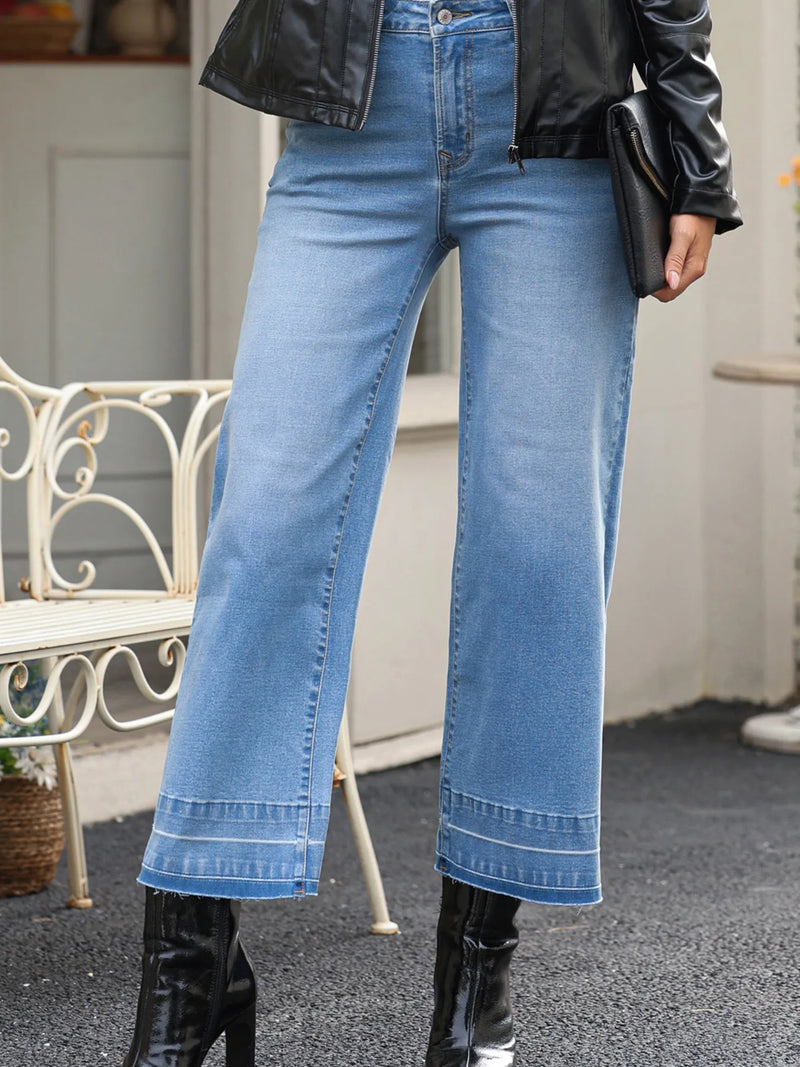 Person wearing blue jeans and black leather jacket with blurred background