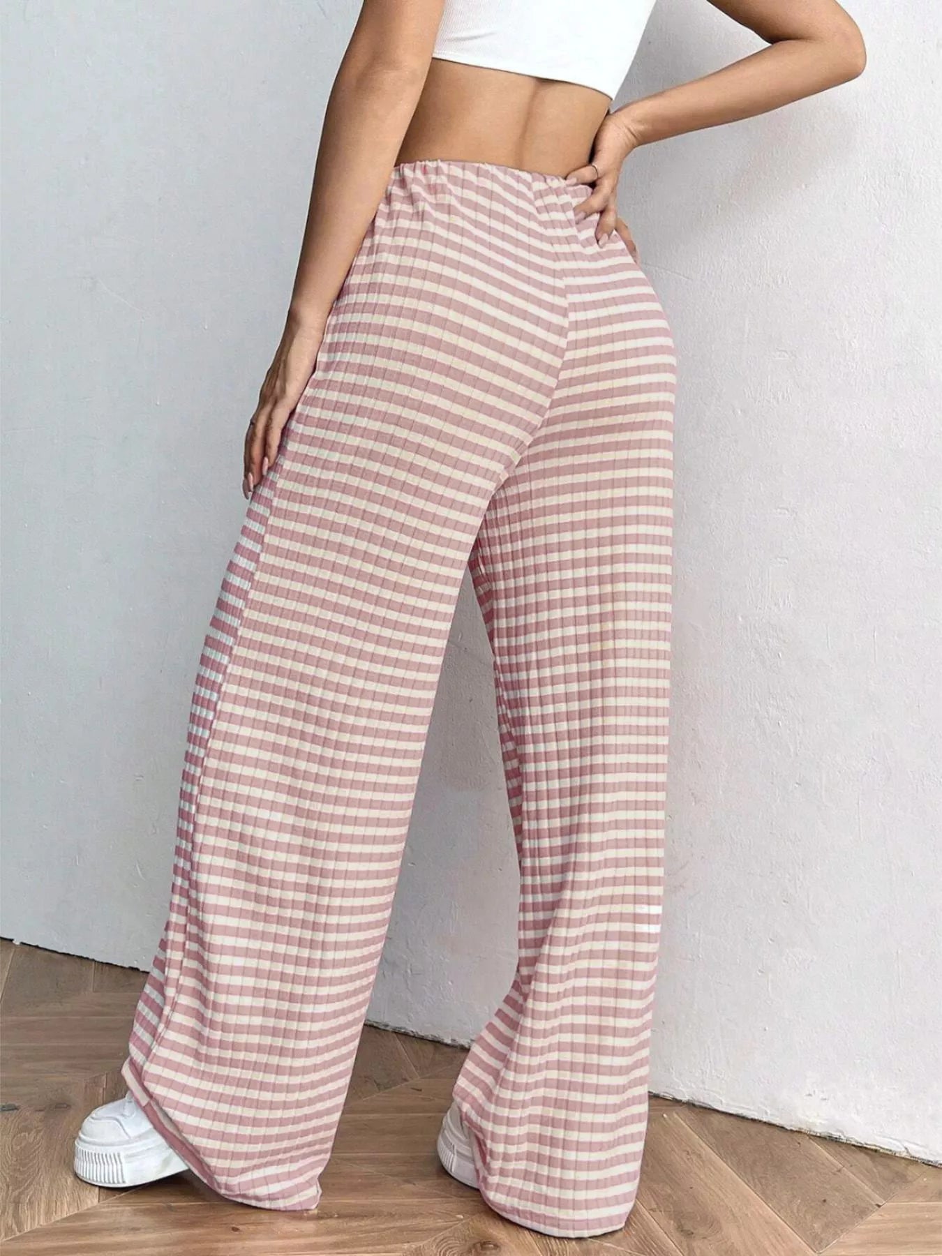 Person wearing pink checkered pants with a white background