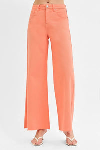 Coral pants worn by a person on a white background