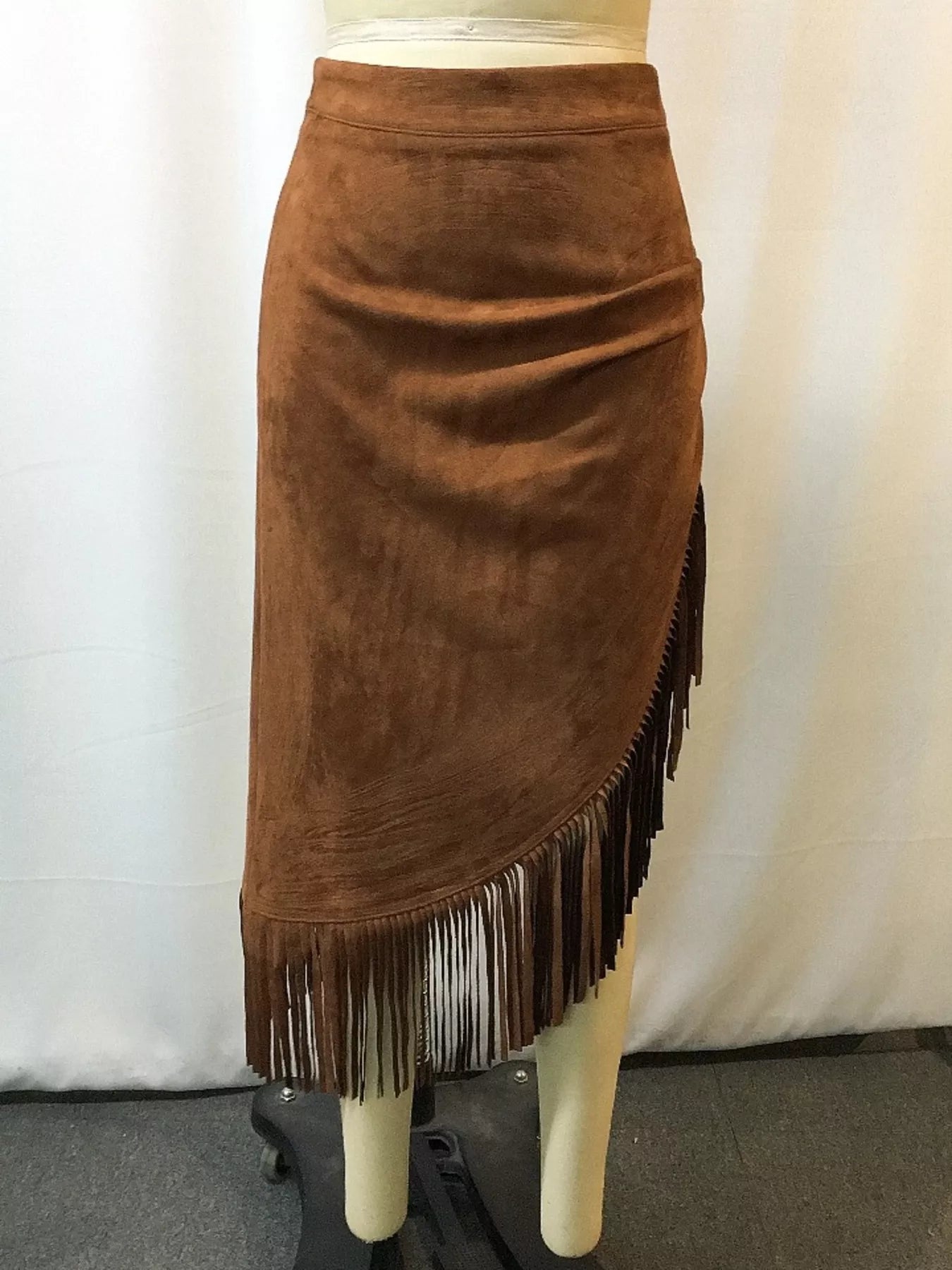 Brown suede skirt with fringe on a mannequin against a white background