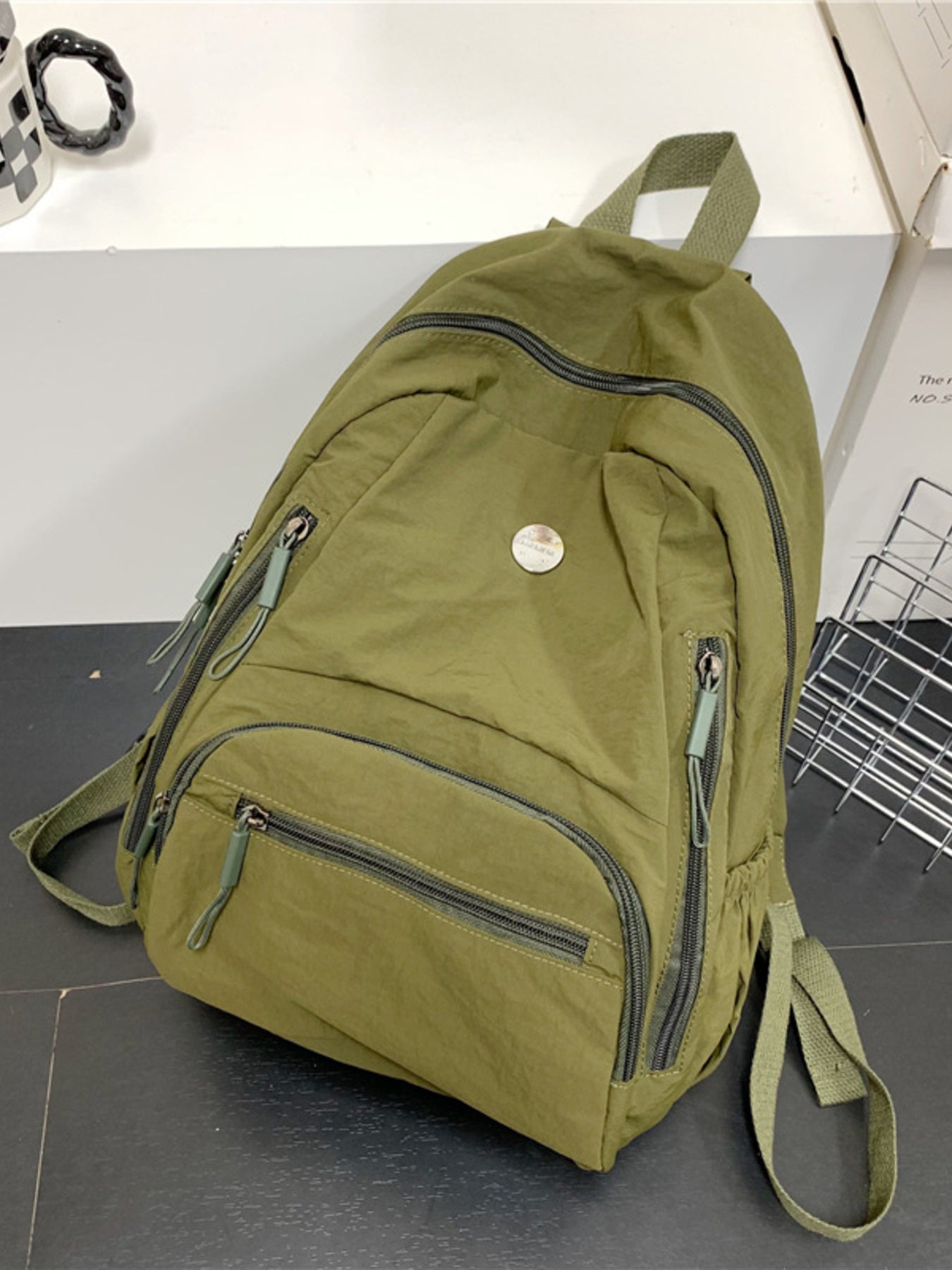 Green backpack on a gray surface with a white background
