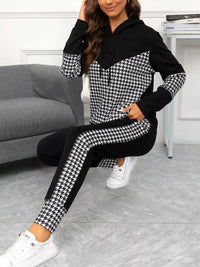 Woman wearing a black and white houndstooth patterned outfit sitting on the floor.
