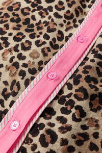 Close-up of a pink belt with buttons on a leopard print fabric background