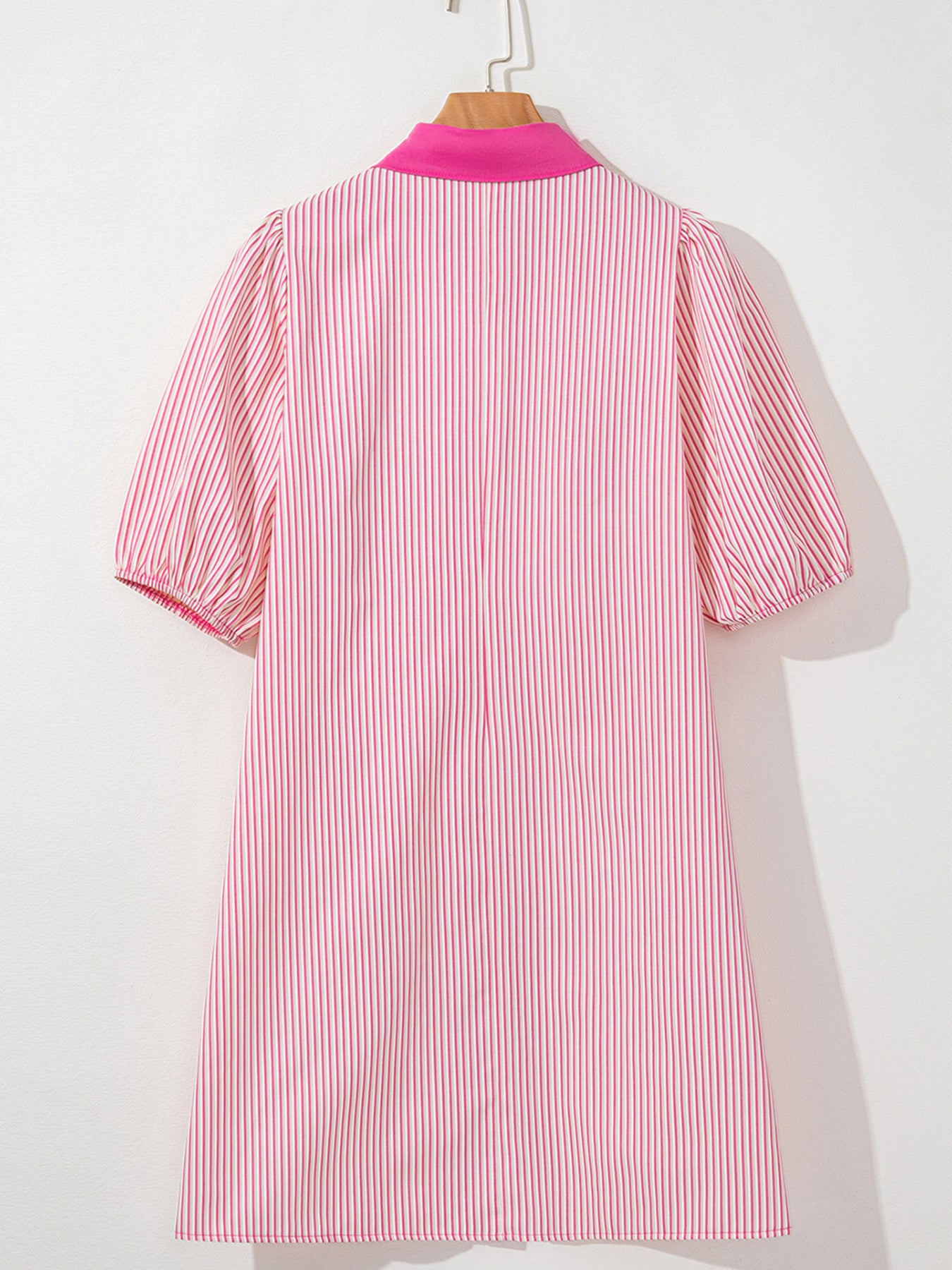 Pink and white striped dress on a mannequin against a white background