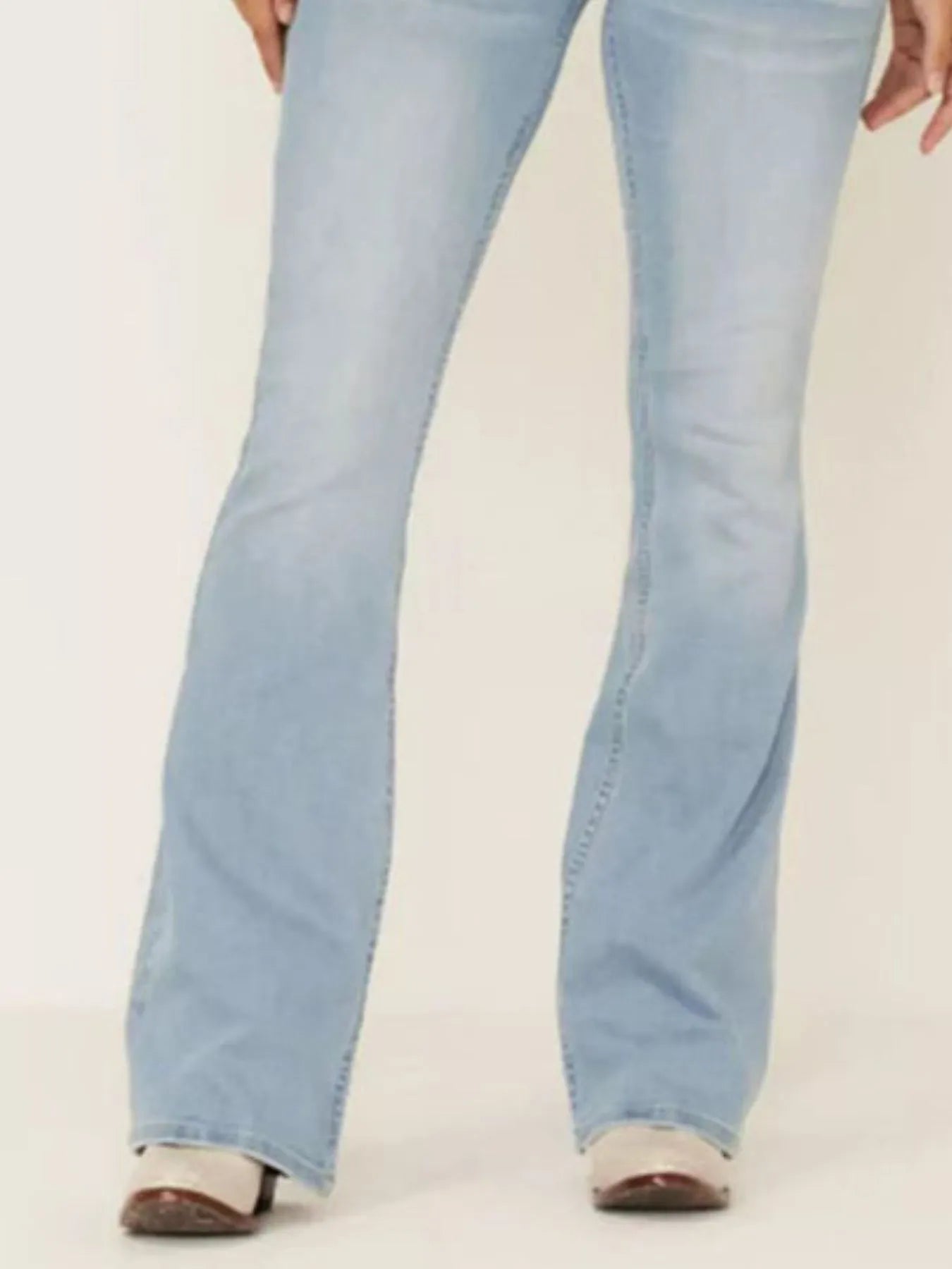Light blue jeans worn by a person on a white background