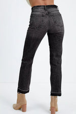 Black jeans worn by a person on a white background