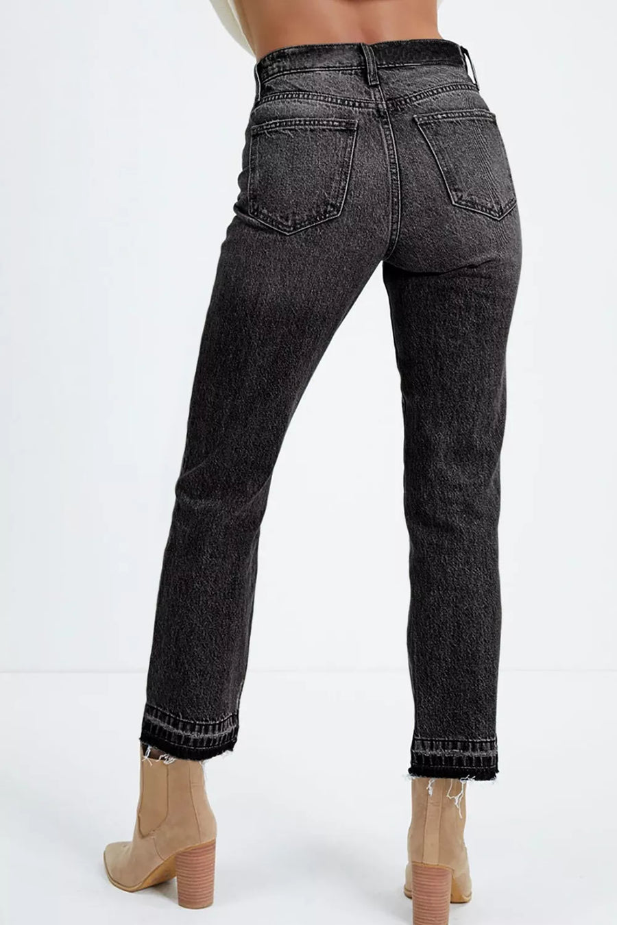 Black jeans worn by a person on a white background