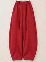 Red wide-leg harem pants with an elastic drawstring waist, shown flat against a light beige background.