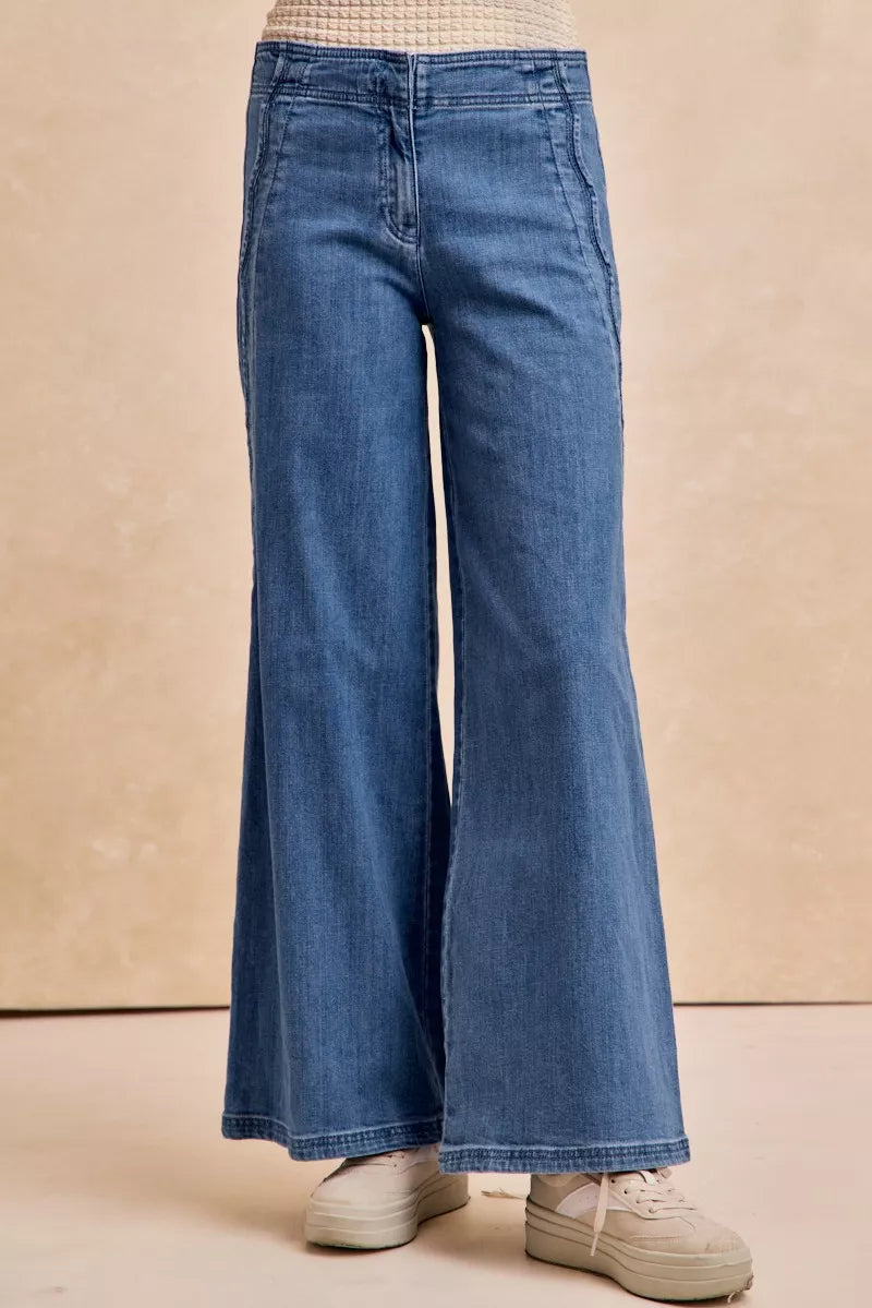 Blue wide-leg jeans on a beige background
